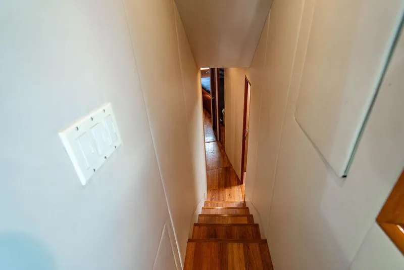 Slide: The Image of Stairway inside 2006 Viking 56 Convertible yacht, featuring wooden steps and hallway view. - 34