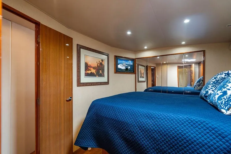 Slide: The Image of Luxurious bedroom interior of 2006 Viking 56 Convertible yacht with blue bedding and artwork. - 35