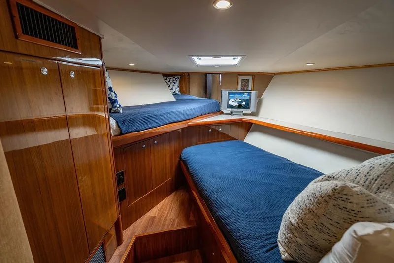 Slide: The Image of 2006 Viking 56 Convertible yacht cabin with twin beds and wooden cabinetry. - 50