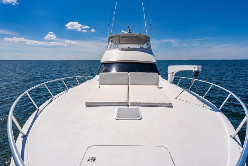 Slide: The Image of 2006 Viking 56 Convertible yacht on open sea under clear blue sky. - 63