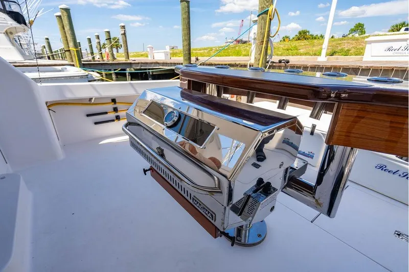 Slide: The Image of 2006 Viking 56 Convertible yacht with a stainless steel grill on deck. - 68