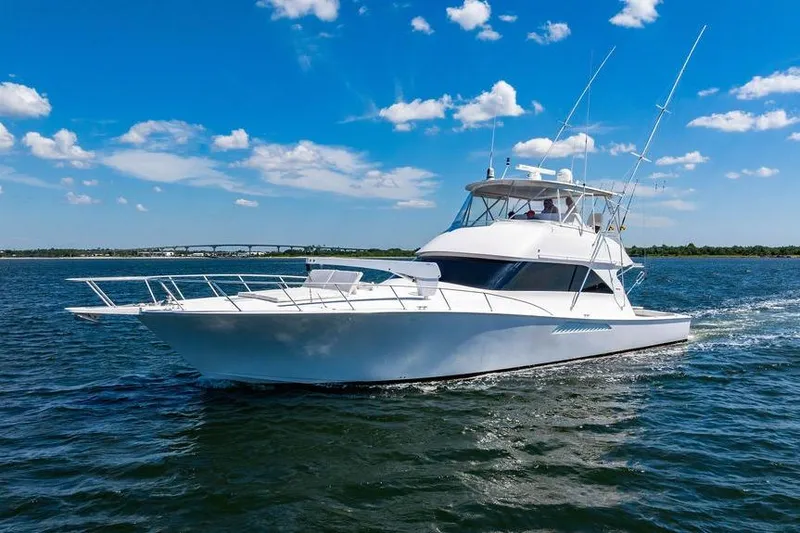 Slide: The Image of 2006 Viking 56 Convertible yacht cruising on open water under a clear blue sky. - 85