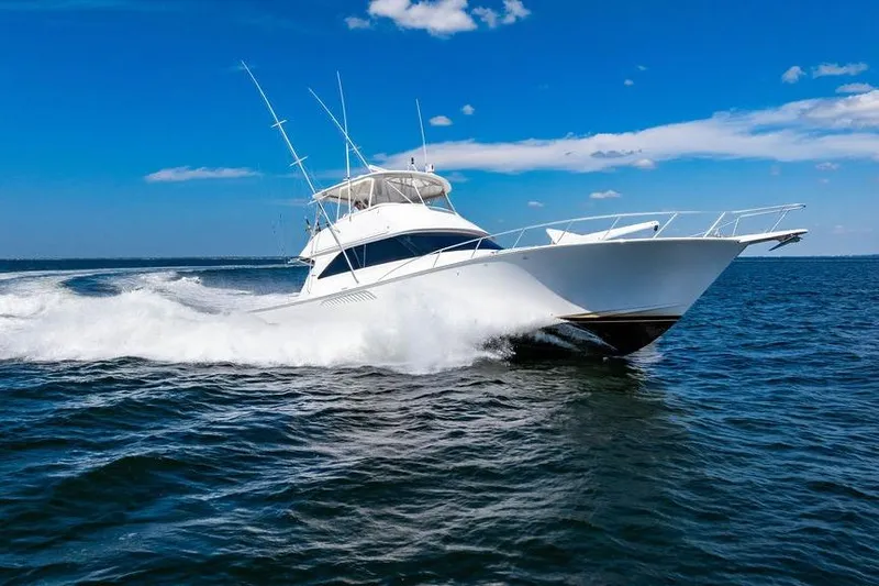 Slide: The Image of 2006 Viking 56 Convertible yacht cruising on open water under a clear blue sky. - 88