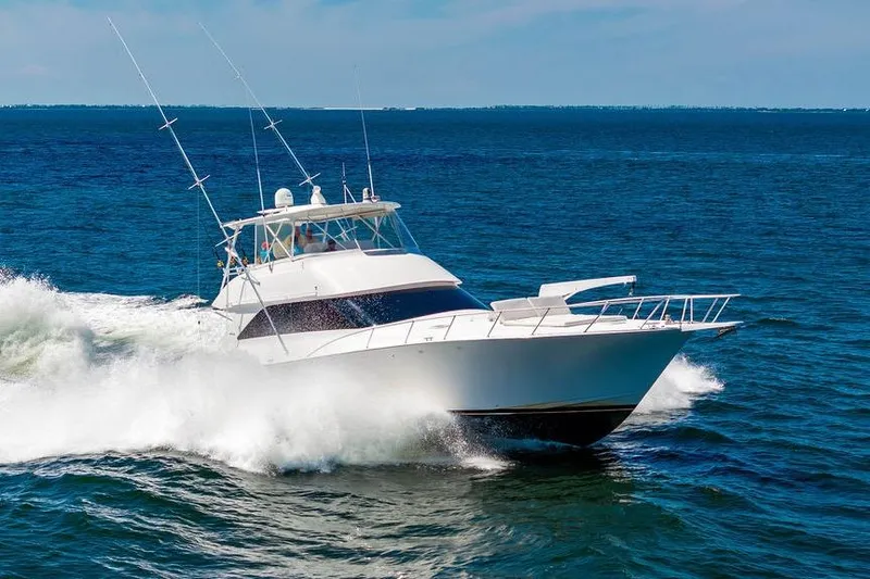 Slide: The Image of 2006 Viking 56 Convertible yacht cruising on open sea, creating waves. - 92