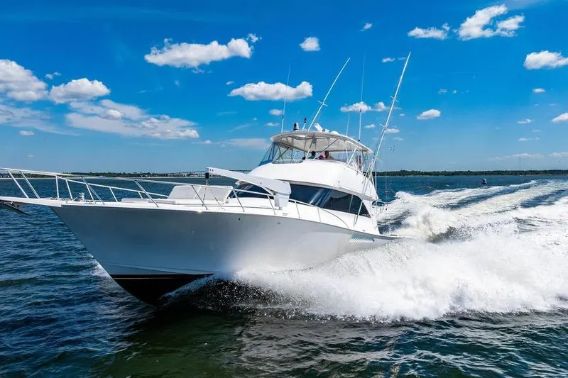 Slide: The Image of 2006 Viking 56 Convertible yacht cruising on open water under a clear blue sky. - 94