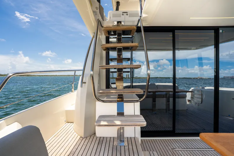 Slide: The Image of Luxury yacht deck with modern staircase, Prestige 520, 2023 model, overlooking serene ocean view. - 18