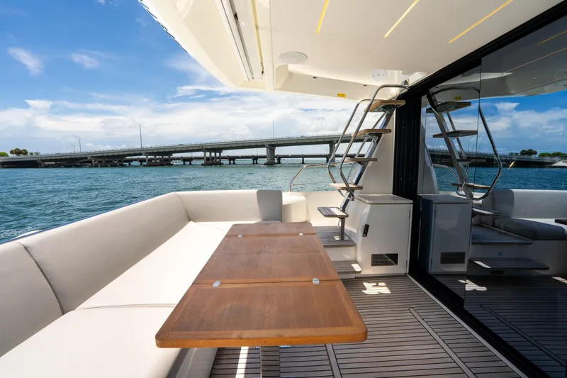 Slide: The Image of Luxurious 2023 Prestige 520 yacht deck with seating, table, and ocean view. - 20