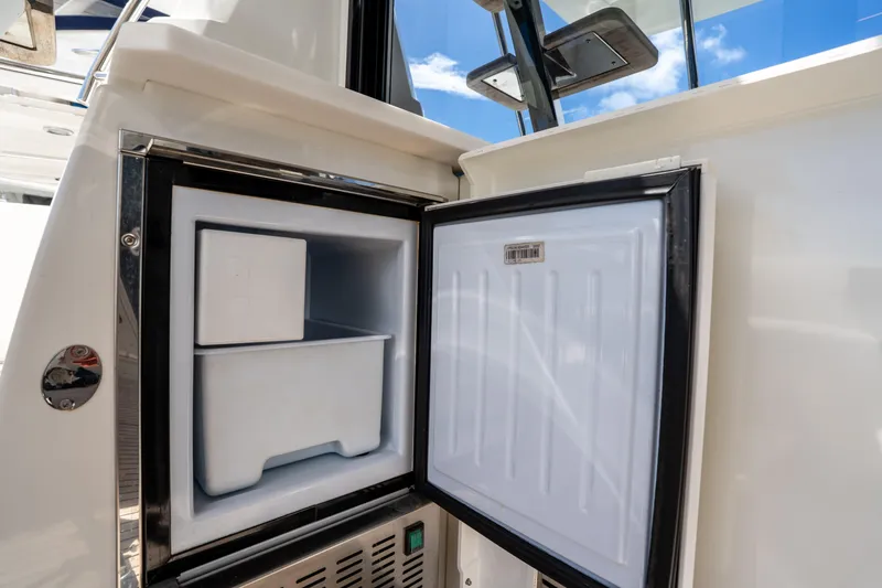 Slide: The Image of Open refrigerator on 2023 Prestige 520 yacht, showcasing interior storage space. - 26