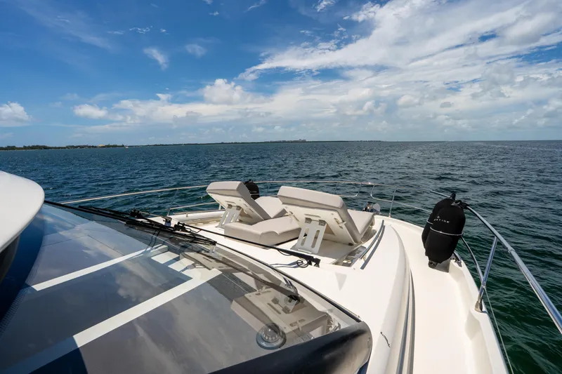 Slide: The Image of Luxury 2023 Prestige 520 yacht cruising on open sea under clear blue sky. - 28