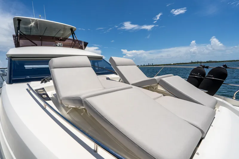 Slide: The Image of Luxury 2023 Prestige 520 yacht with sun loungers on deck, under clear blue sky. - 30