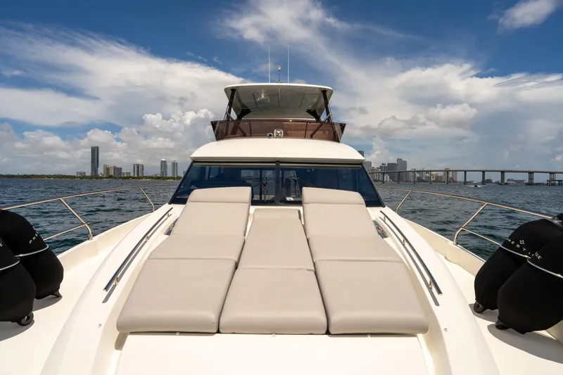 Slide: The Image of Luxury 2023 Prestige 520 yacht cruising with city skyline and bridge in the background. - 31