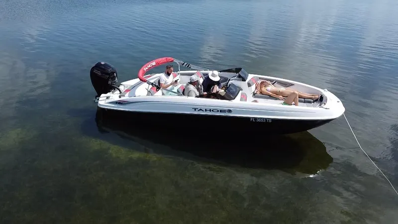 Slide: The Image of 2024 Tahoe T21 boat with passengers relaxing on calm water. - 2