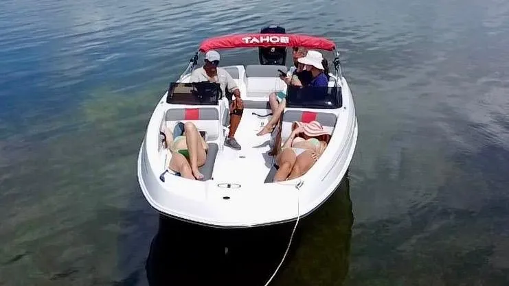 Slide: The Image of 2024 Tahoe T21 boat with red canopy on clear water, aerial view. - 4