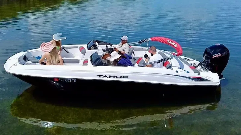 Slide: The Image of 2024 Tahoe T21 boat on calm water with passengers relaxing onboard. - 5