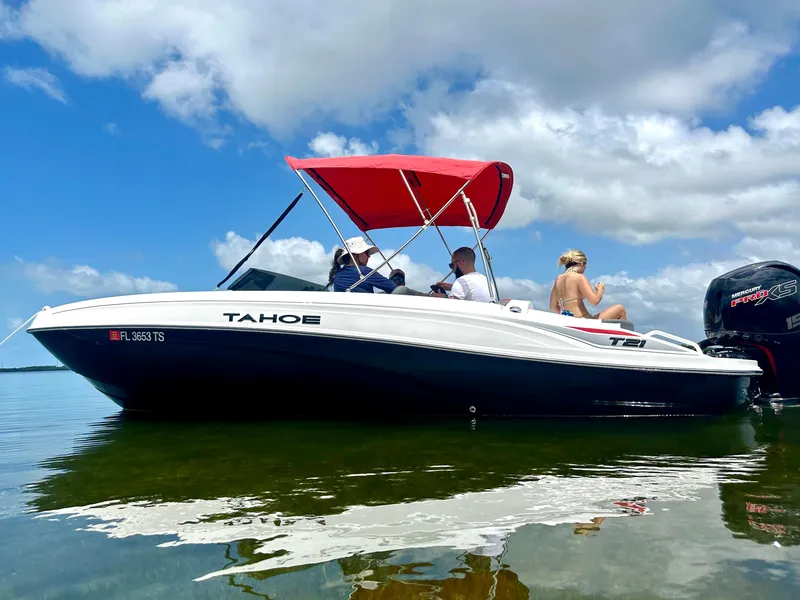 Slide: The Image of 2024 Tahoe T21 boat with passengers on calm water, aerial view. - 8