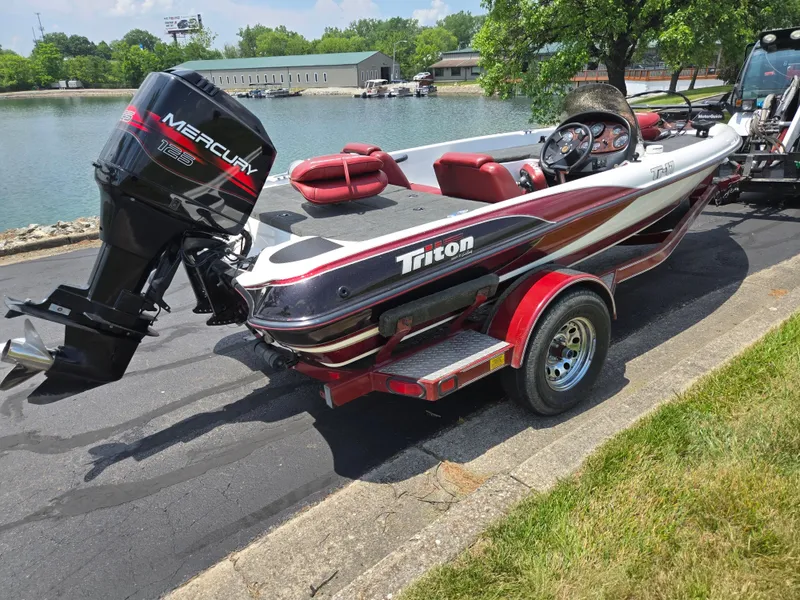 Slide: The Image of 1998 Triton Tr-17 boat with Mercury 125 outboard motor, parked near a lake. - 10