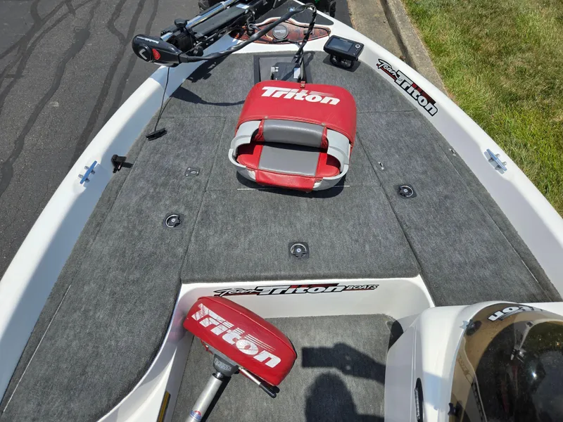 Slide: The Image of 1998 Triton Tr-17 boat interior with red seat and fishing equipment. - 16