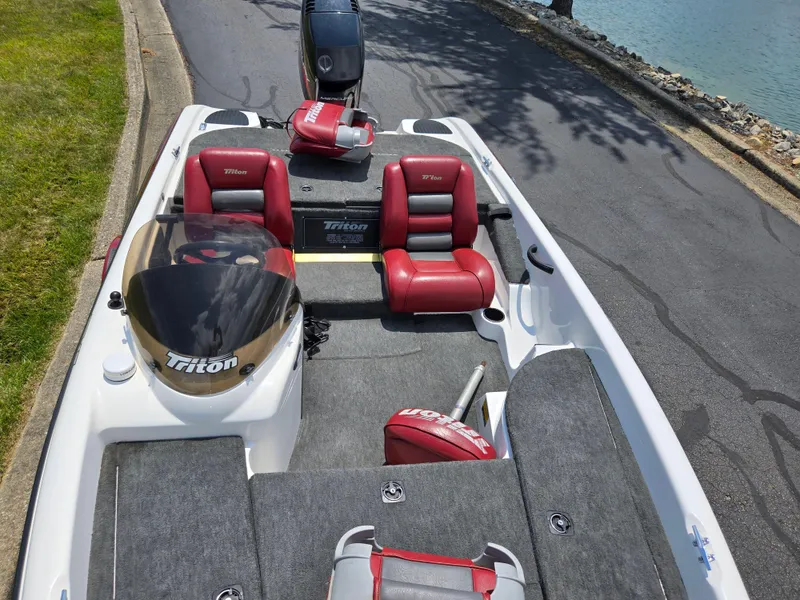 Slide: The Image of 1998 Triton Tr-17 boat with red seats, parked near water on a sunny day. - 20