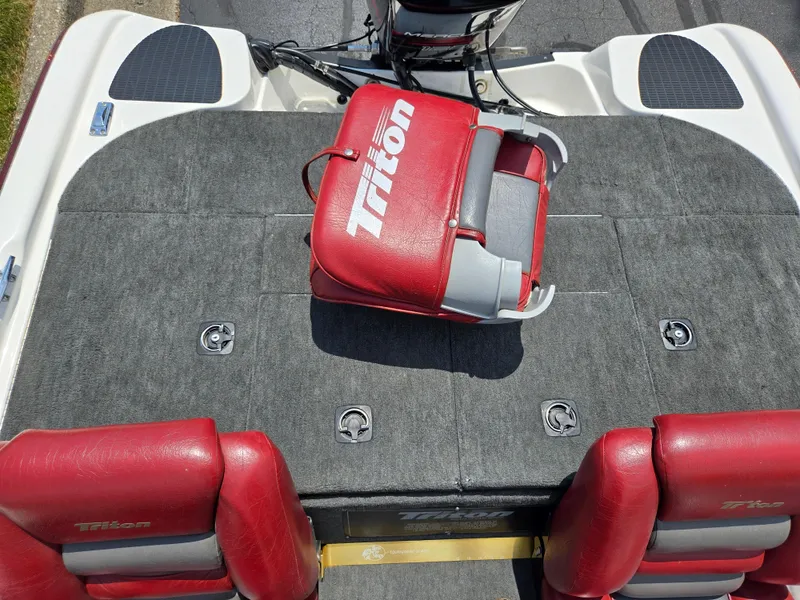 Slide: The Image of 1998 Triton Tr-17 boat interior with red seats and carpeted deck. - 22
