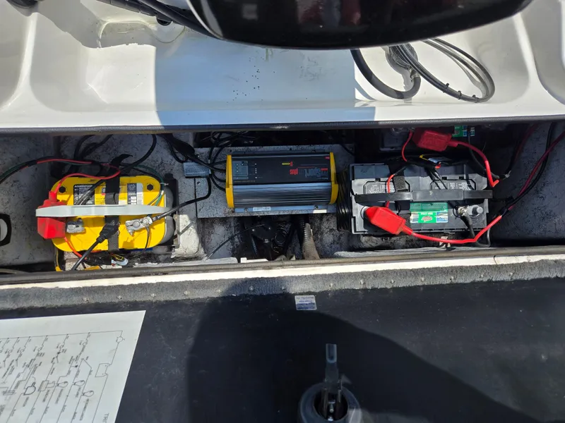 Slide: The Image of 1998 Triton Tr-17 boat battery compartment with dual batteries and charger setup. - 24