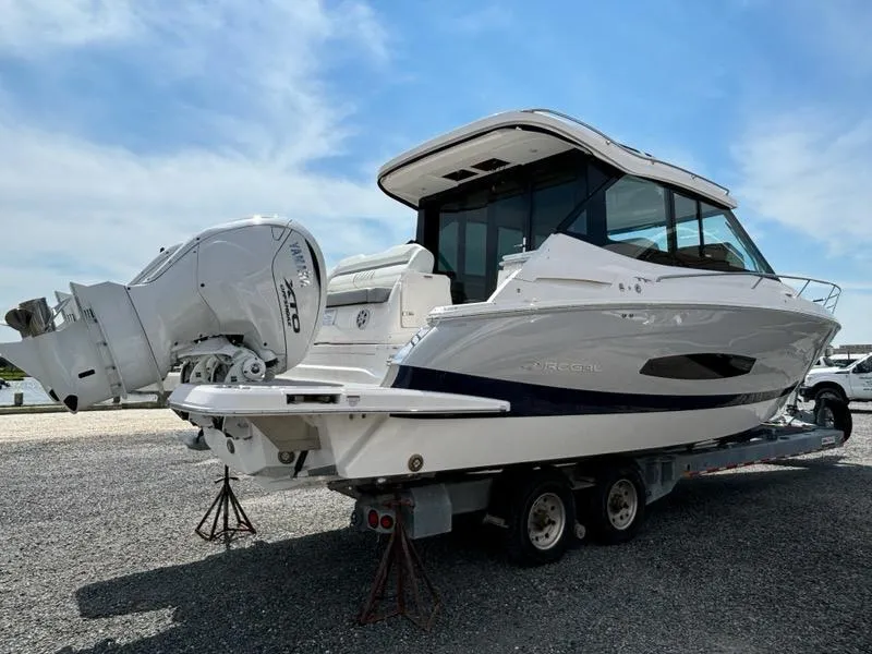 Slide: The Image of 2025 Regal 36 XO boat on trailer, featuring sleek design and powerful outboard engines. - 2