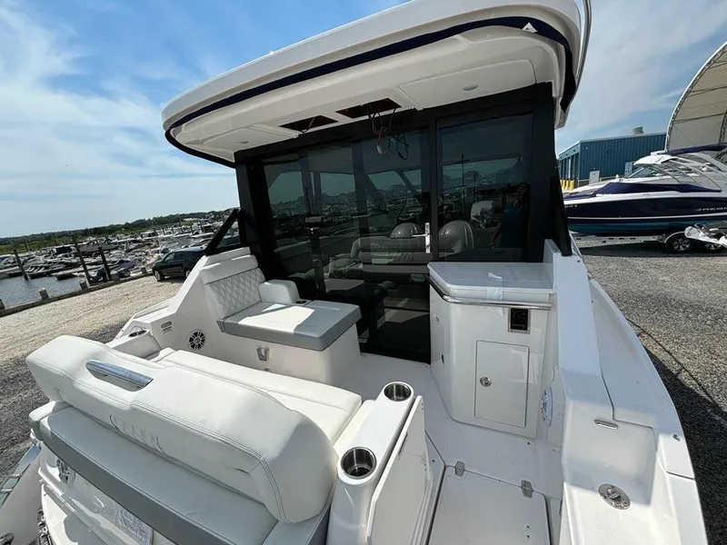 Slide: The Image of 2025 Regal 36 XO yacht with sleek white seating and modern design at a marina. - 35