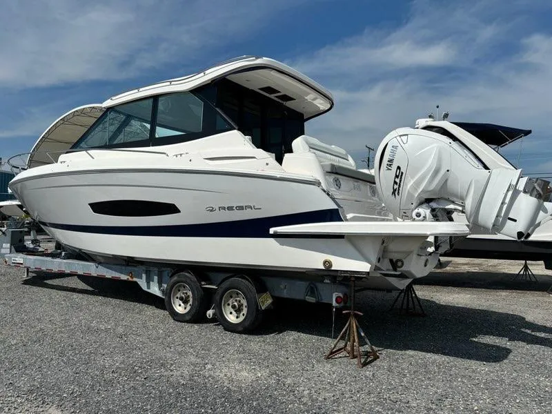 Slide: The Image of 2025 Regal 36 XO boat on trailer, featuring Yamaha outboard engines, parked outdoors. - 4