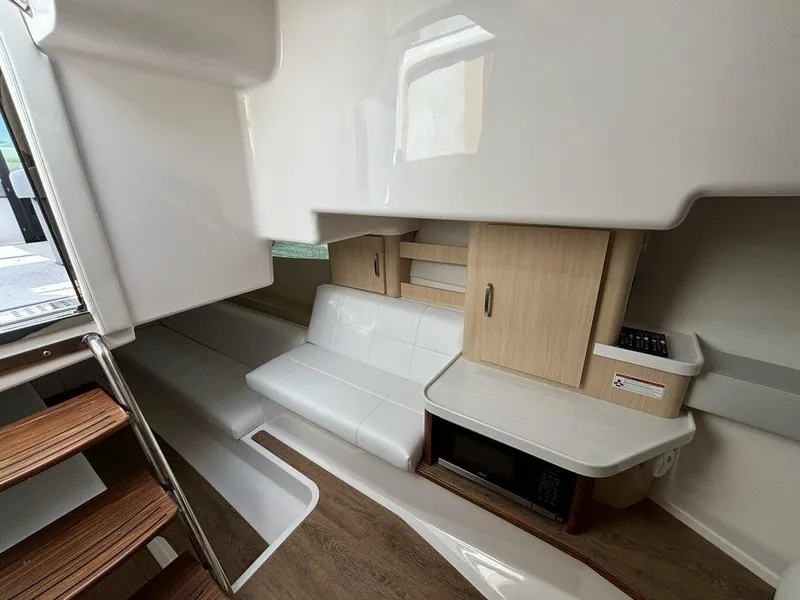 Slide: The Image of 2025 Regal 36 XO interior with modern seating, wooden cabinetry, and compact kitchen area. - 46