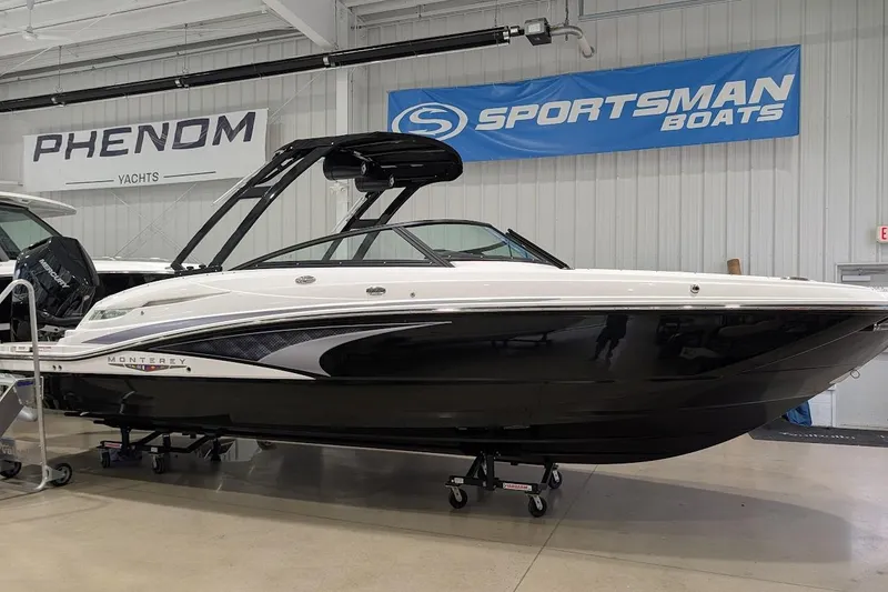 The Image of 2026 Monterey M-65 boat displayed indoors at a showroom with banners. - 0