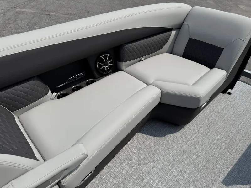 Slide: The Image of The image shows a luxurious seating area on a Harris Sunliner 230 boat, featuring elegant upholstery and speakers. - 24
