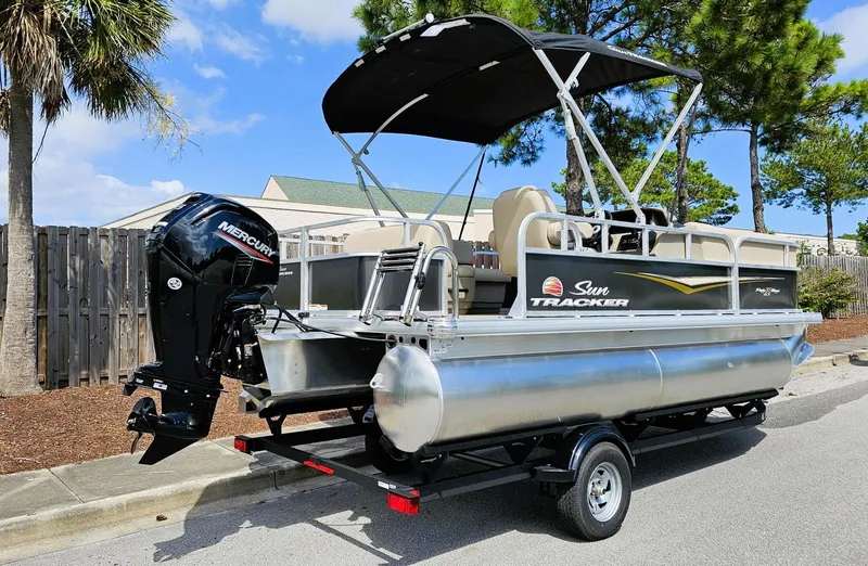 Slide: The Image of 2025 Sun Tracker Party Barge 18 DLX pontoon boat with Mercury engine on trailer. - 2