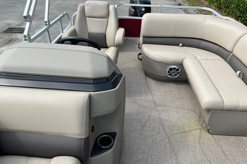Slide: The Image of 2025 Sun Tracker Party Barge 18 DLX interior with beige seating and steering console. - 8