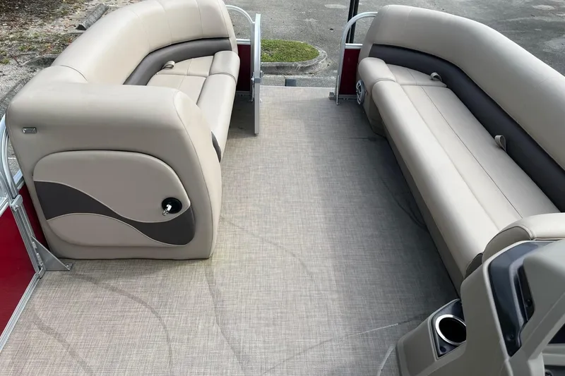 Slide: The Image of 2025 Sun Tracker Party Barge 18 DLX interior with beige seating and carpeted floor. - 9