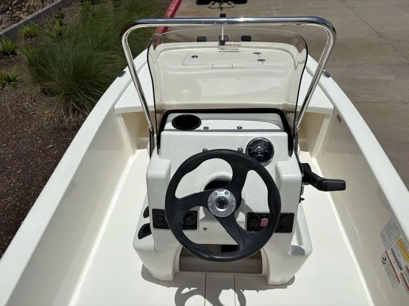 Slide: The Image of 2024 Mako Pro Skiff 13 CC boat console with steering wheel and controls. - 5