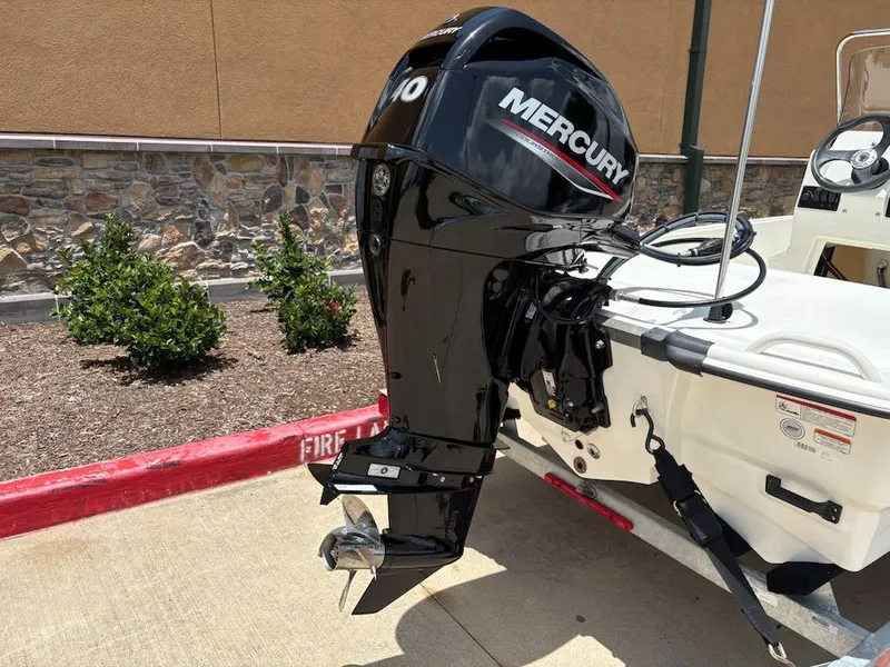 Slide: The Image of 2024 Mako Pro Skiff 13 CC with Mercury outboard motor, parked on a trailer. - 6