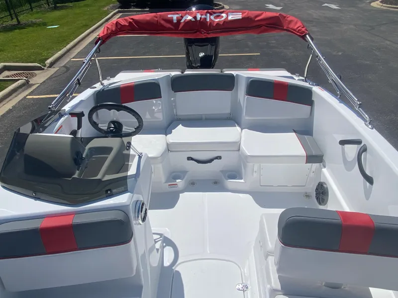 Slide: The Image of 2025 Tahoe T16 boat interior with red and gray seating, steering wheel, and windshield. - 7