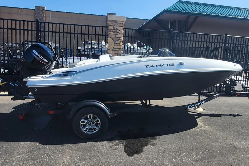 The Image of 2025 Tahoe T16 boat on trailer, parked outdoors, featuring sleek design and Mercury engine. - 0