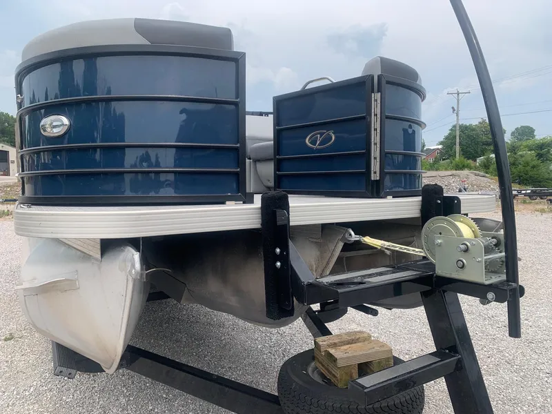 Slide: The Image of 2019 Veranda Relax VR25RC pontoon boat on trailer in outdoor setting. - 2