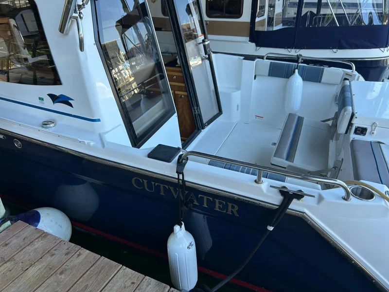 Slide: The Image of 2017 Cutwater C-242 Coupe boat docked, featuring open cockpit and seating area. - 14