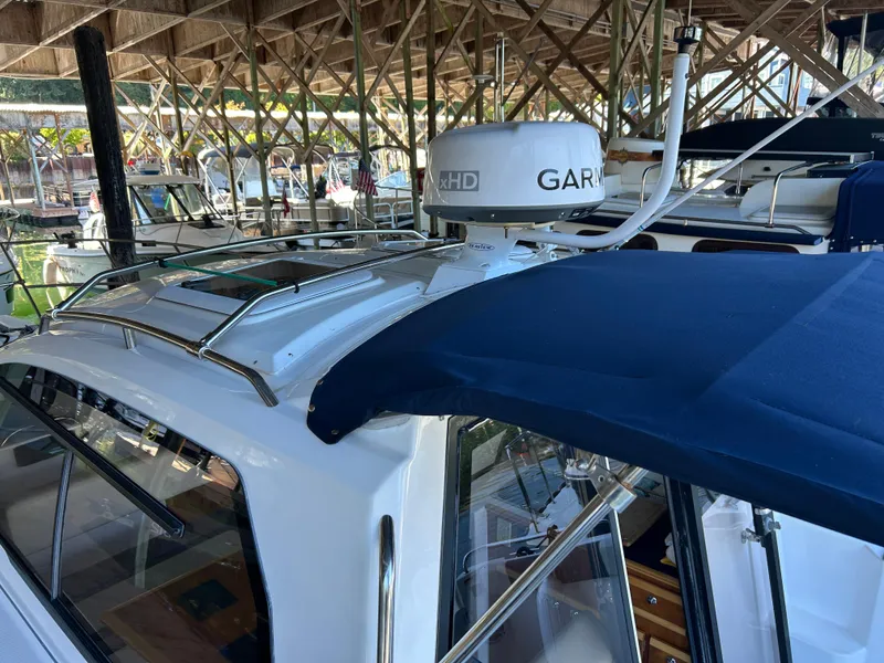 Slide: The Image of 2017 Cutwater C-242 Coupe boat with Garmin radar, docked under a wooden canopy. - 15