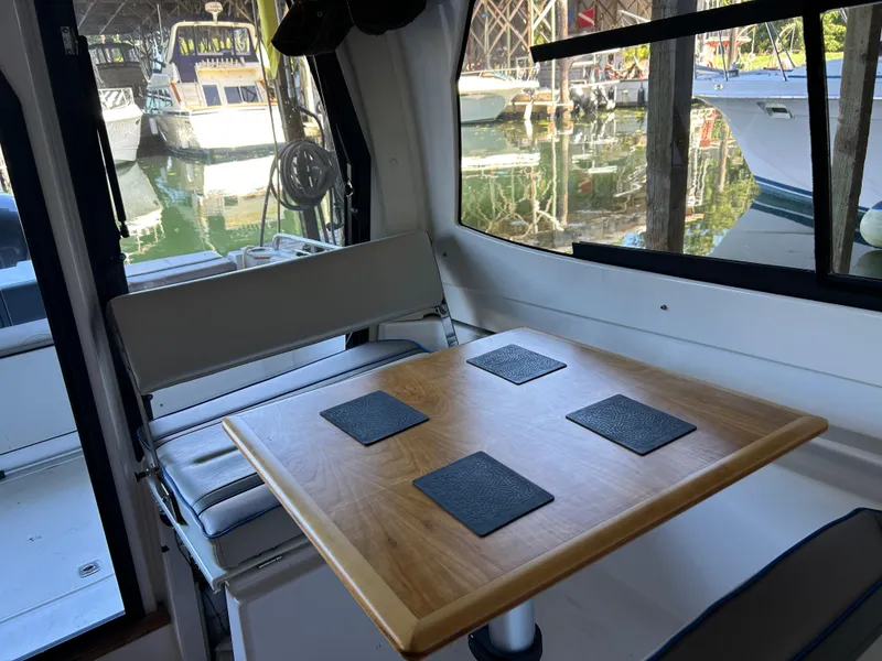 Slide: The Image of Interior of a 2017 Cutwater C-242 Coupe with a wooden table and seating. - 19