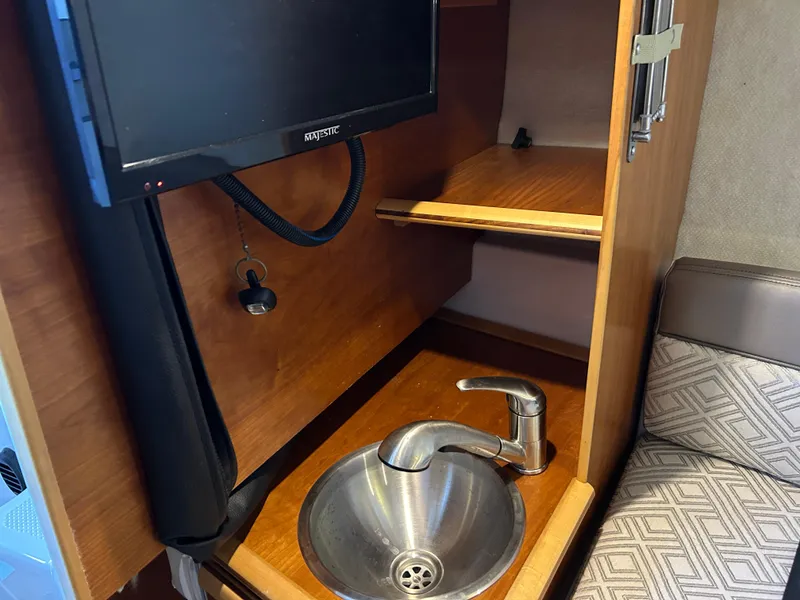 Slide: The Image of Interior of 2017 Cutwater C-242 Coupe featuring a sink and mounted TV. - 4