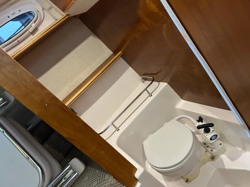 Slide: The Image of 2017 Cutwater C-242 Coupe boat bathroom with toilet and wooden accents. - 6