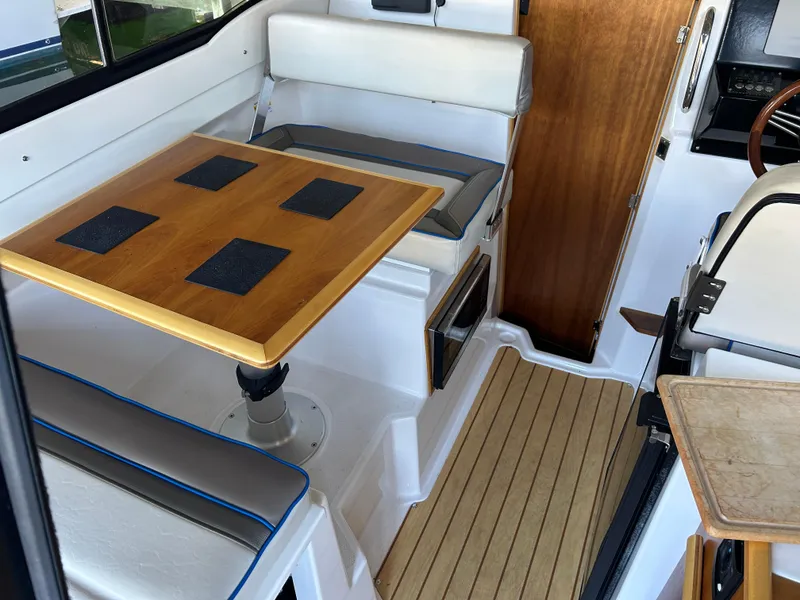 Slide: The Image of Interior of 2017 Cutwater C-242 Coupe featuring a wooden table and cushioned seating. - 9