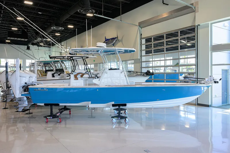Slide: The Image of 2026 Valhalla Boatworks V-28 in showroom, blue hull, modern design. - 2