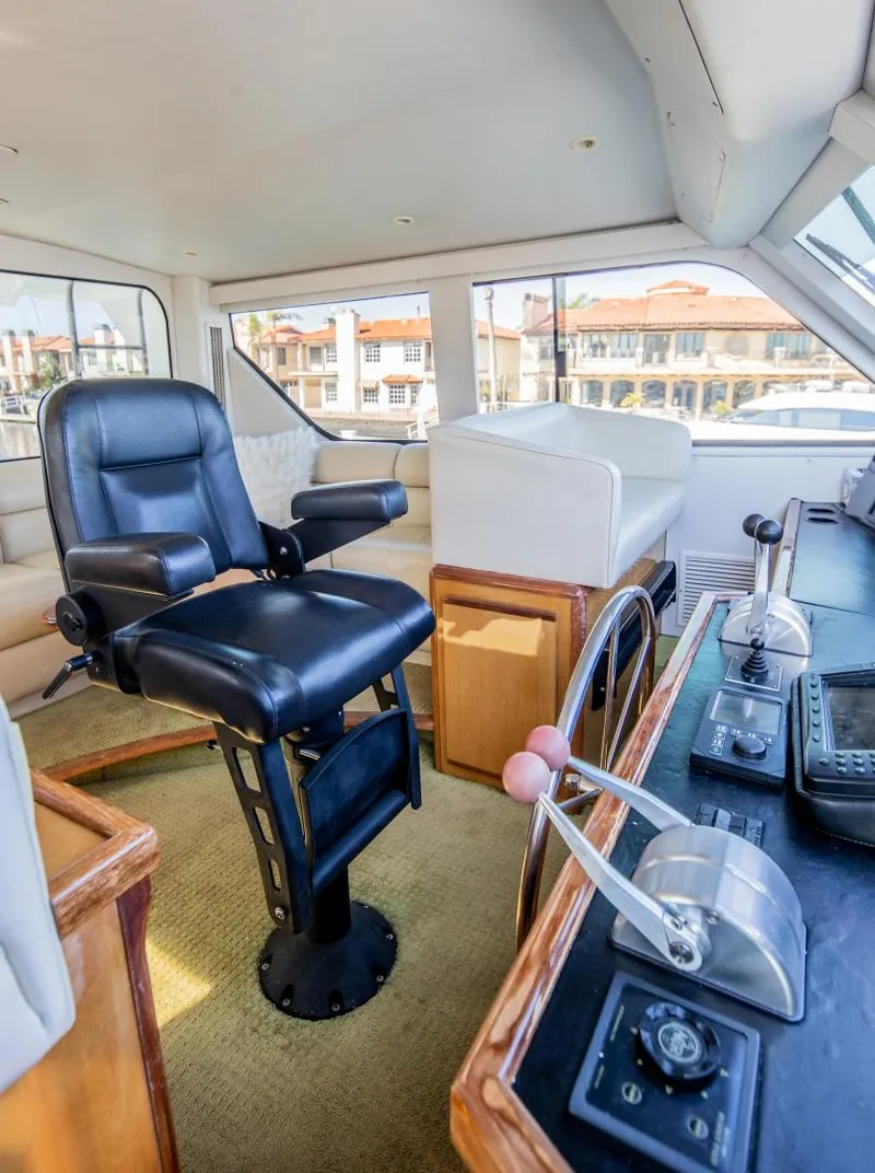 Slide: The Image of 1999 Viking 58 Enclosed Bridge helm with leather captain's chair and navigation controls. - 10