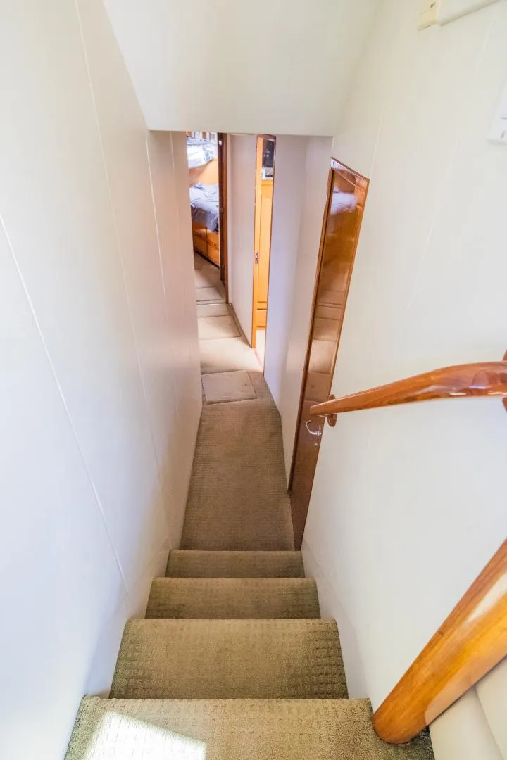 Slide: The Image of Stairway inside 1999 Viking 58 Enclosed Bridge yacht with wooden handrail. - 16