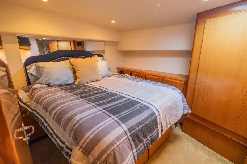 Slide: The Image of Luxurious bedroom interior of 1999 Viking 58 Enclosed Bridge yacht with cozy bedding. - 17