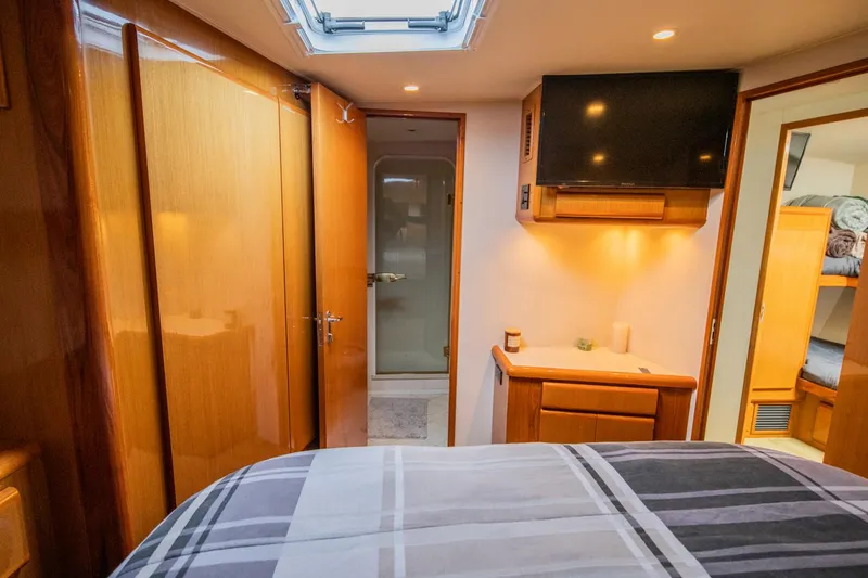 Slide: The Image of Luxurious interior of 1999 Viking 58 Enclosed Bridge yacht bedroom with TV and ensuite bathroom. - 18