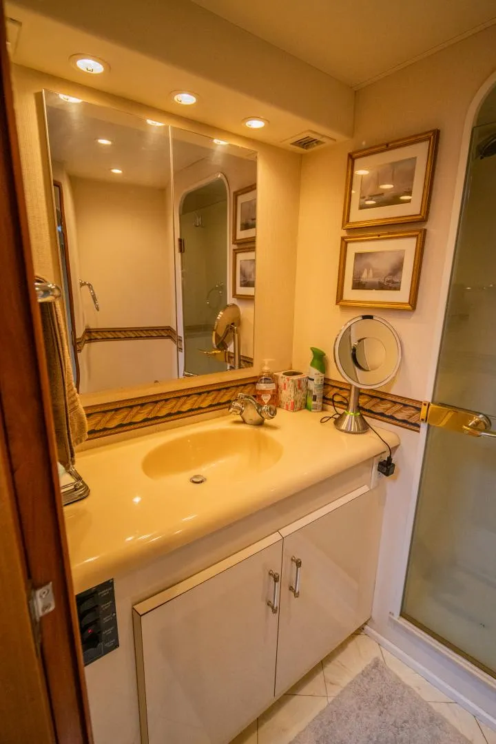 Slide: The Image of Bathroom interior of 1999 Viking 58 Enclosed Bridge yacht, featuring sink and mirror. - 19